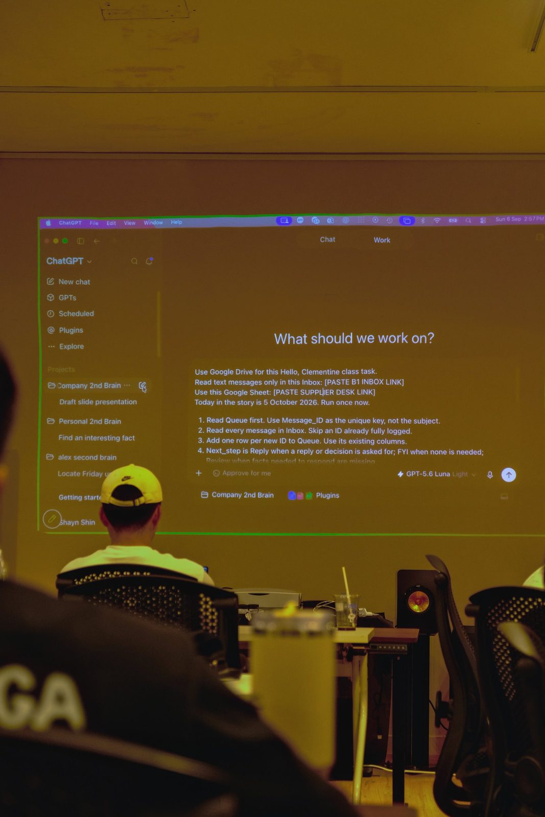 A projected chat window asking what should we work on, above the class