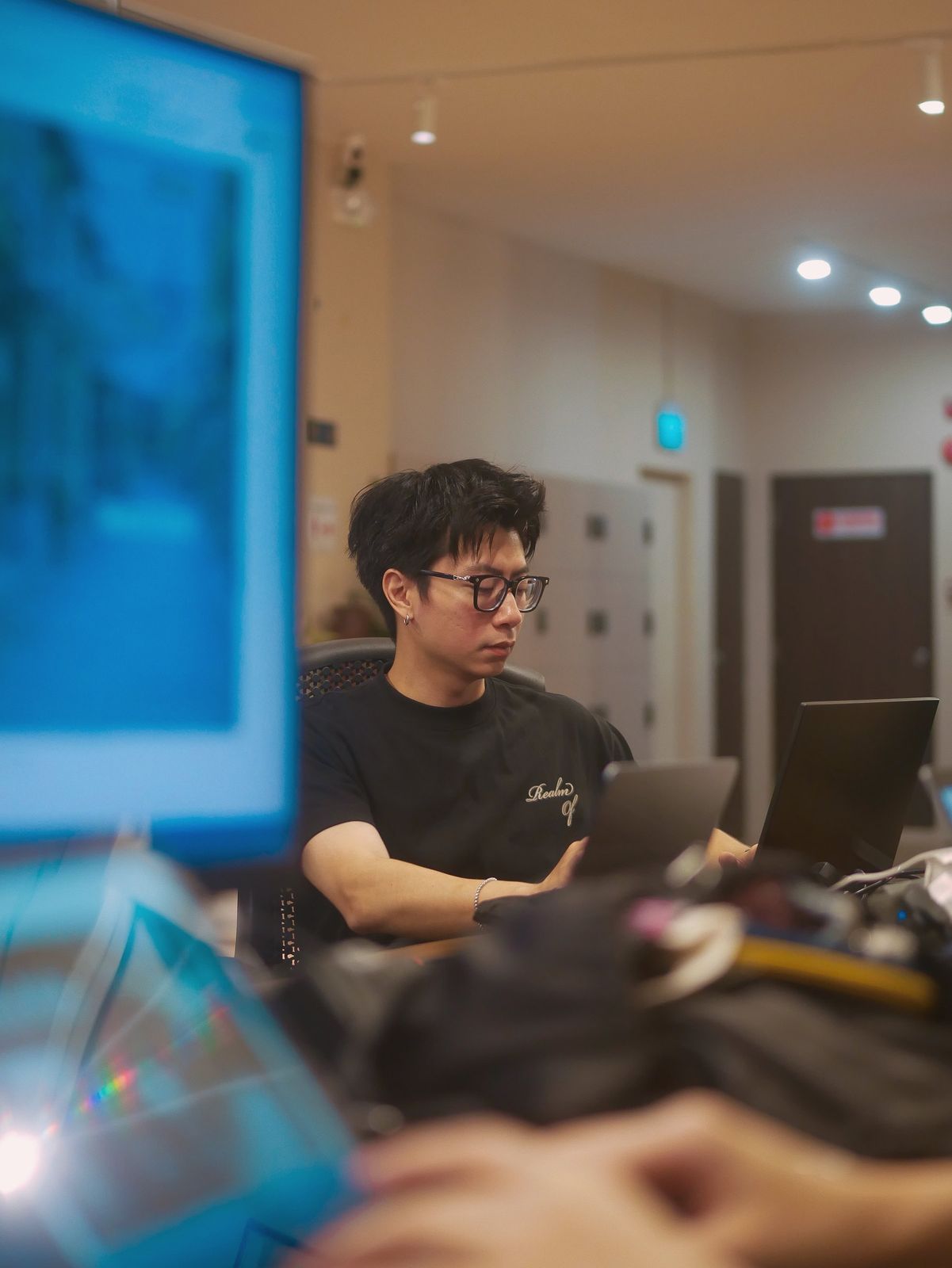 A learner at work on a laptop in class, the projected screen behind